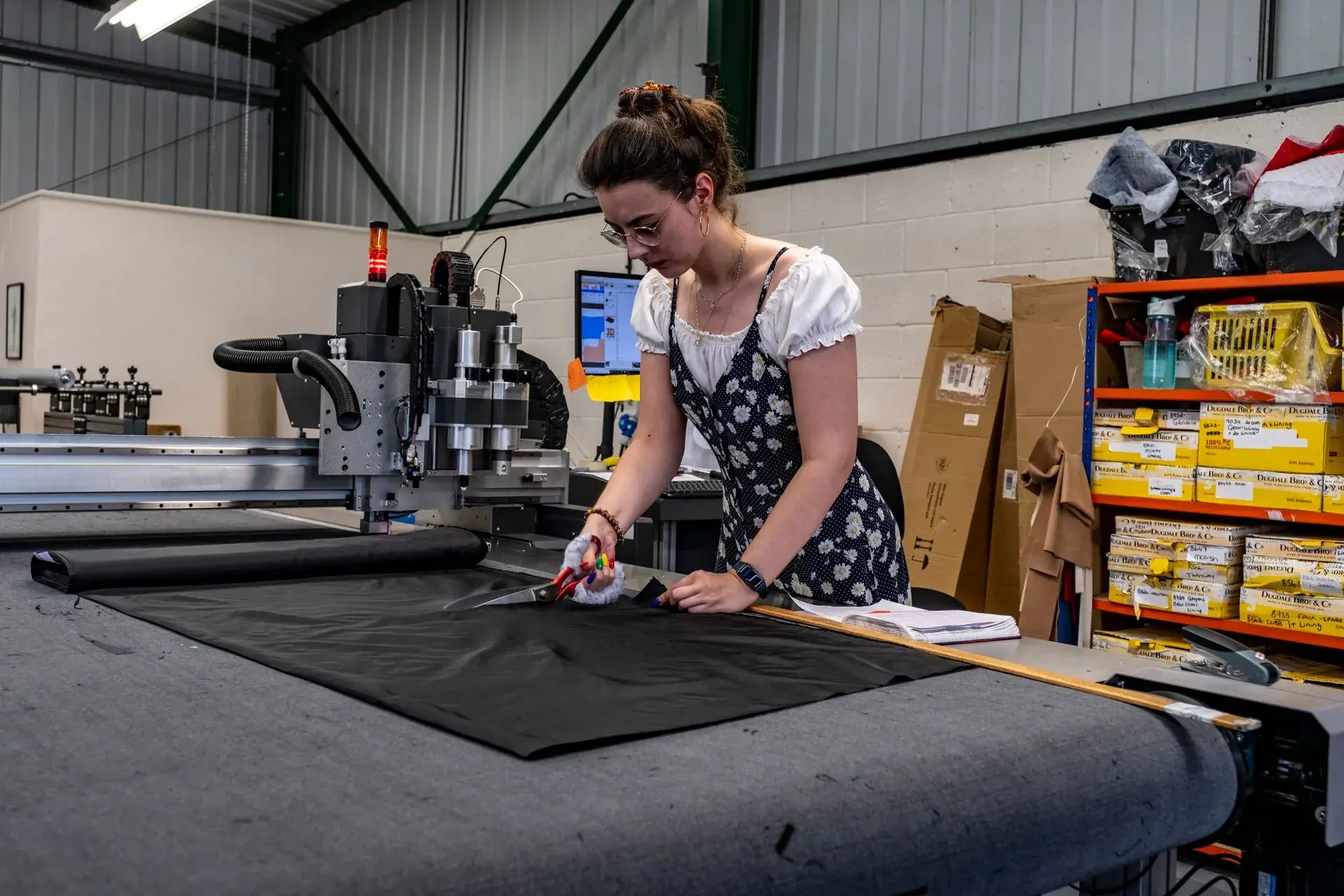 Pattern cutter measuring and cutting fabric on a cutting table — stock illustration standing in for Marker laid and panels being cut at Lahajam, Lahore