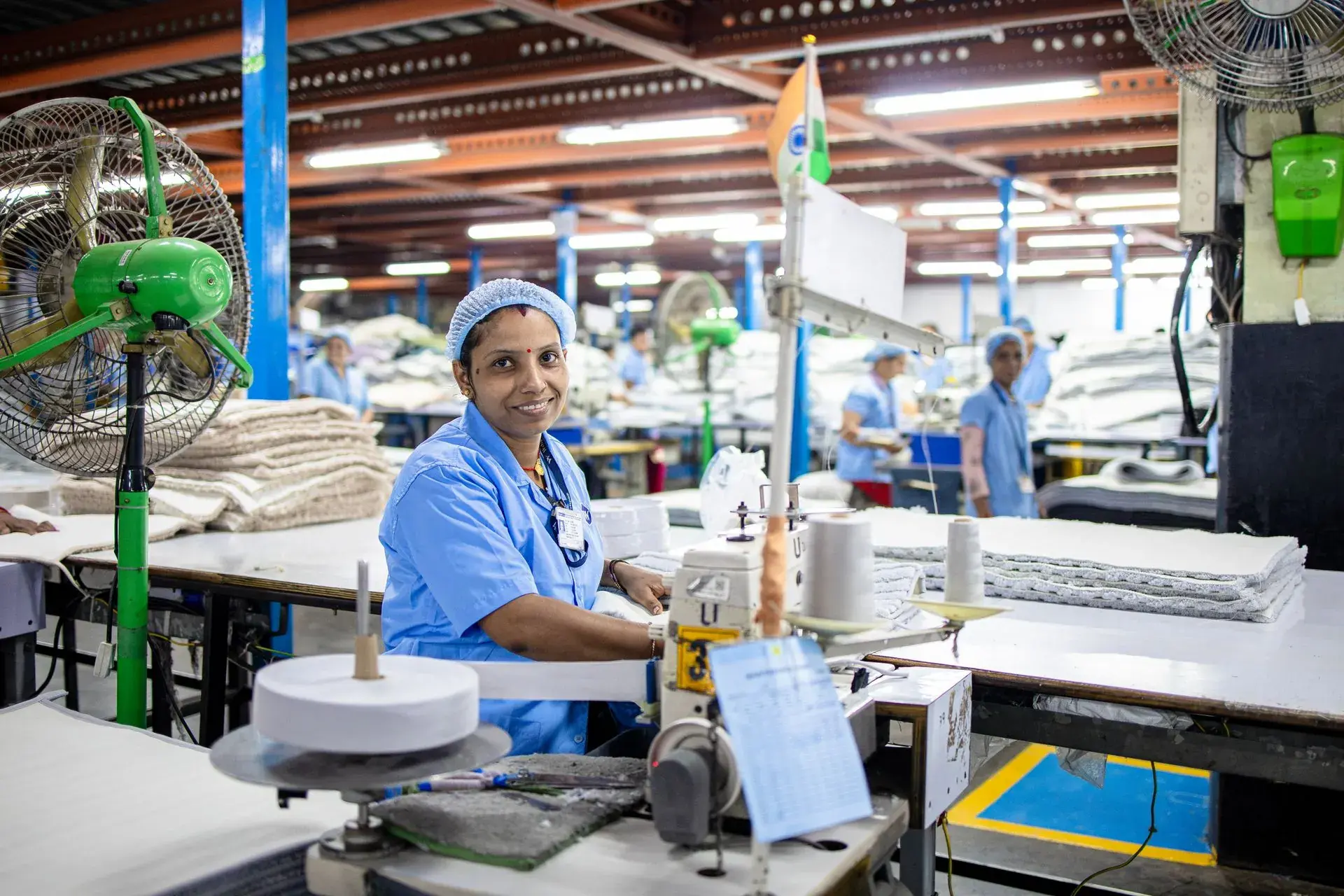 Fabric spread on a long cutting table in a garment factory — stock illustration standing in for Fabric spreading on the cutting table at Lahajam, Lahore