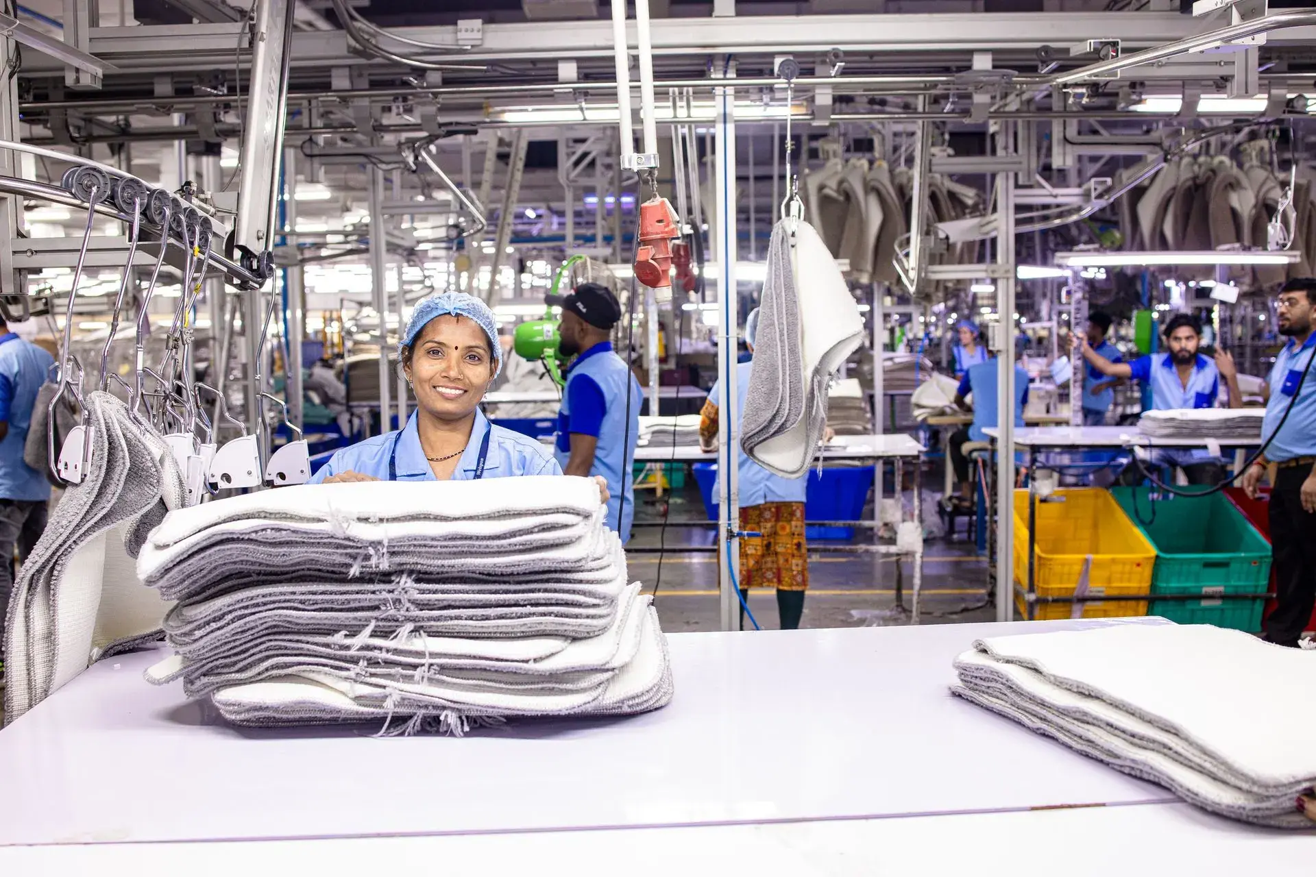 Operator folding finished garments in the finishing section — stock illustration standing in for Thread trimming and pressing at Lahajam, Lahore