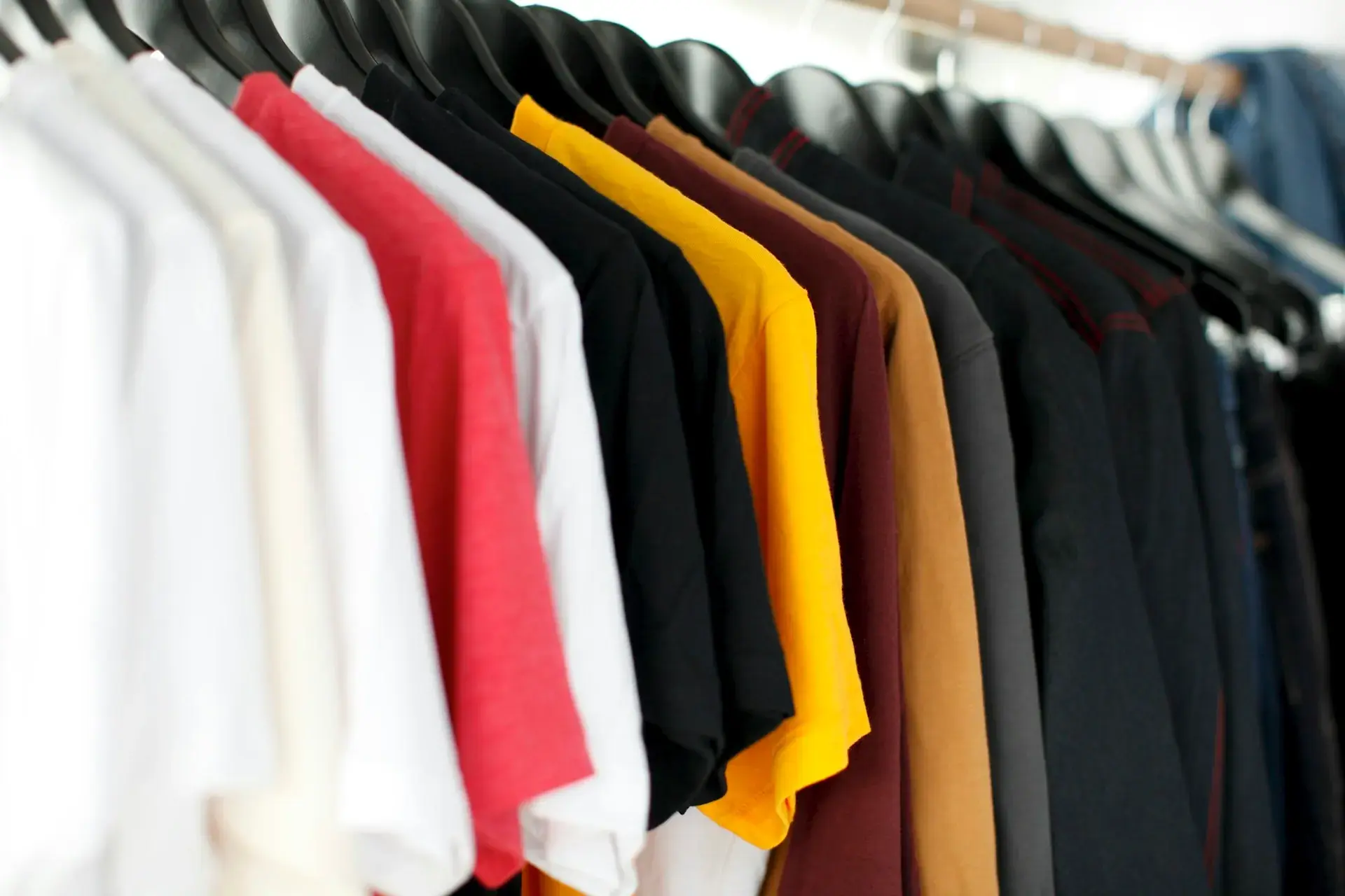 Jackets in several colours hanging on a rail — stock illustration for uniforms