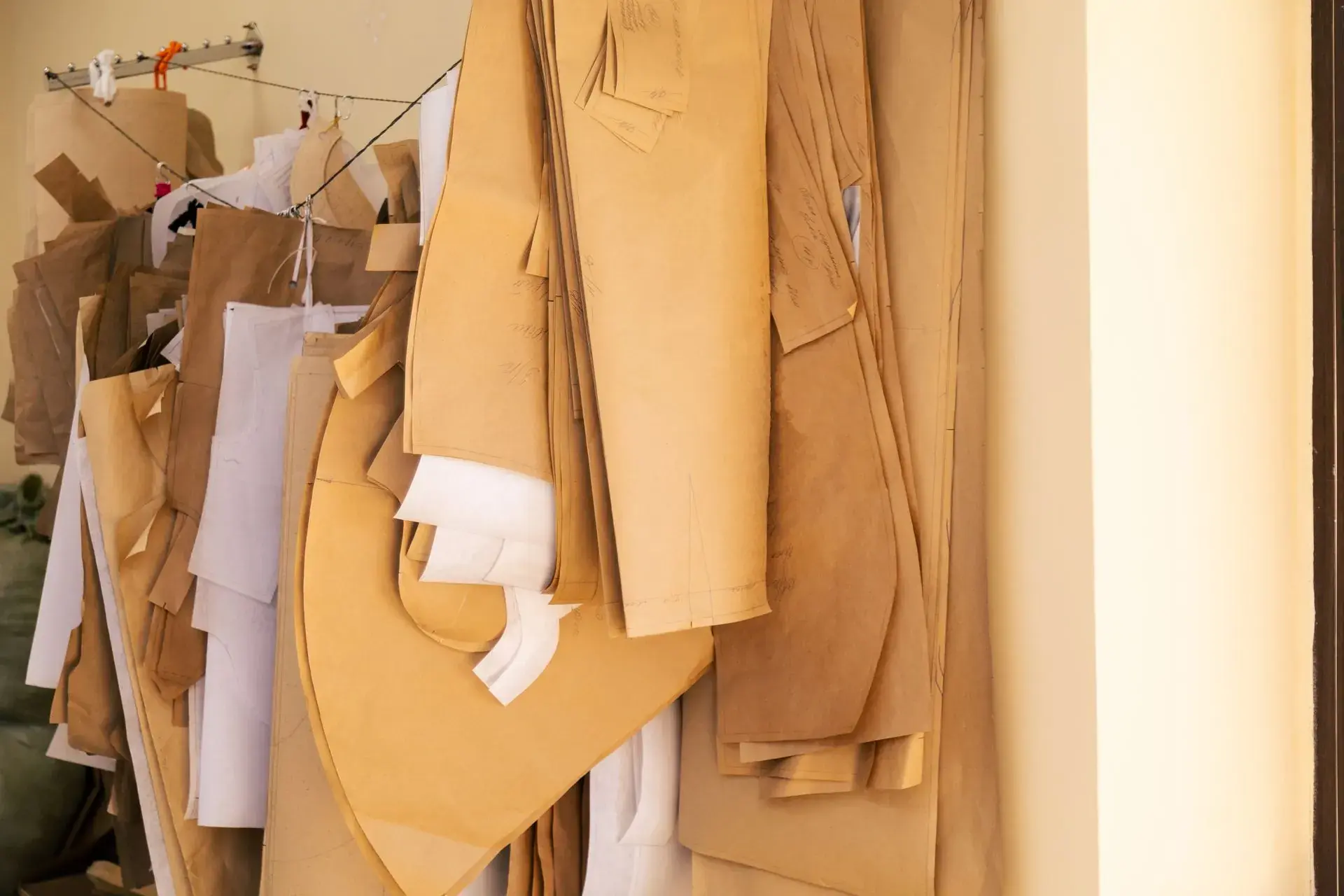 Paper pattern pieces laid out for a new garment style — stock illustration standing in for Pattern master working on a new style at Lahajam, Lahore