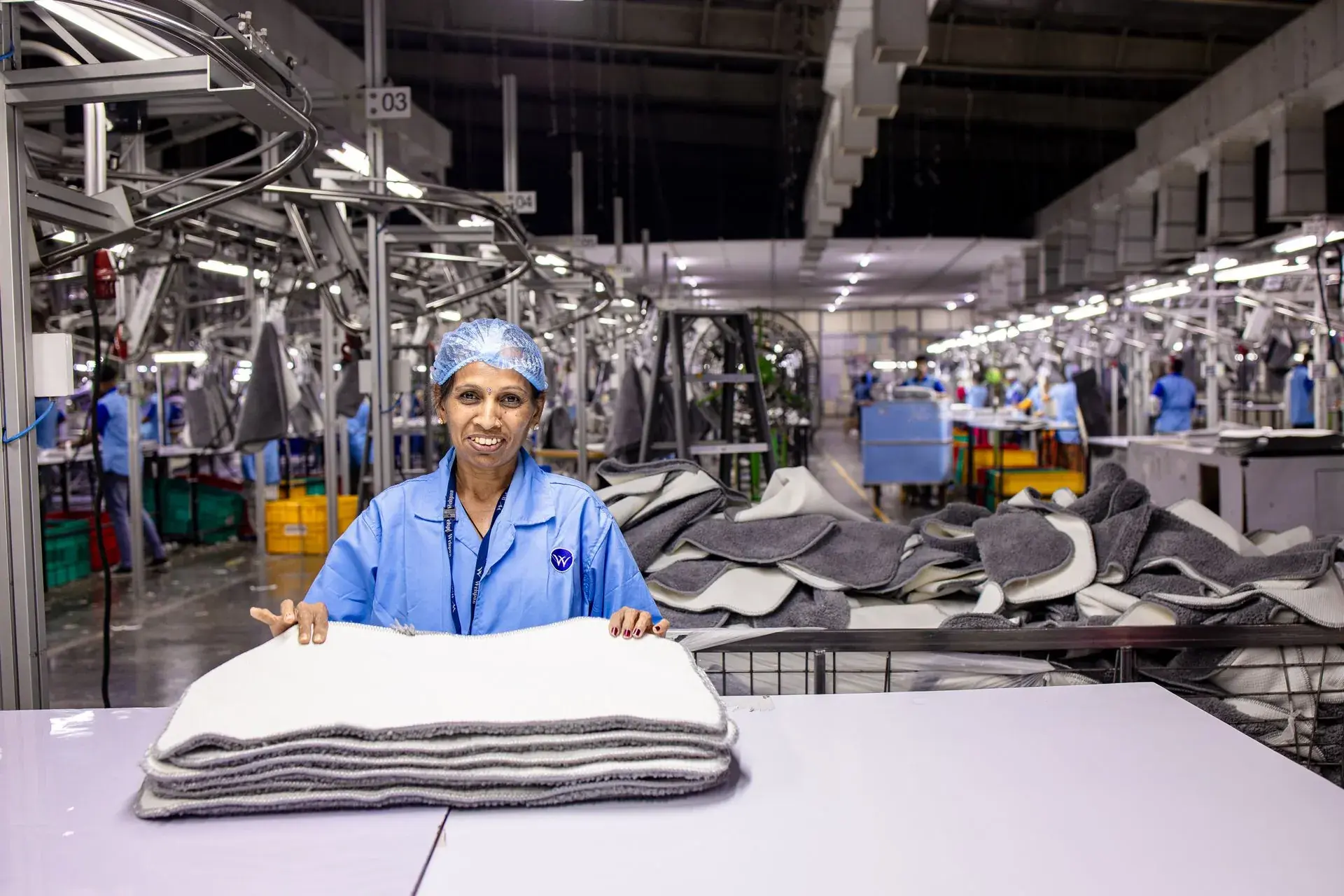 Inspector checking stacks of finished garments on an inspection table — stock illustration standing in for End-of-line inspection table at Lahajam, Lahore