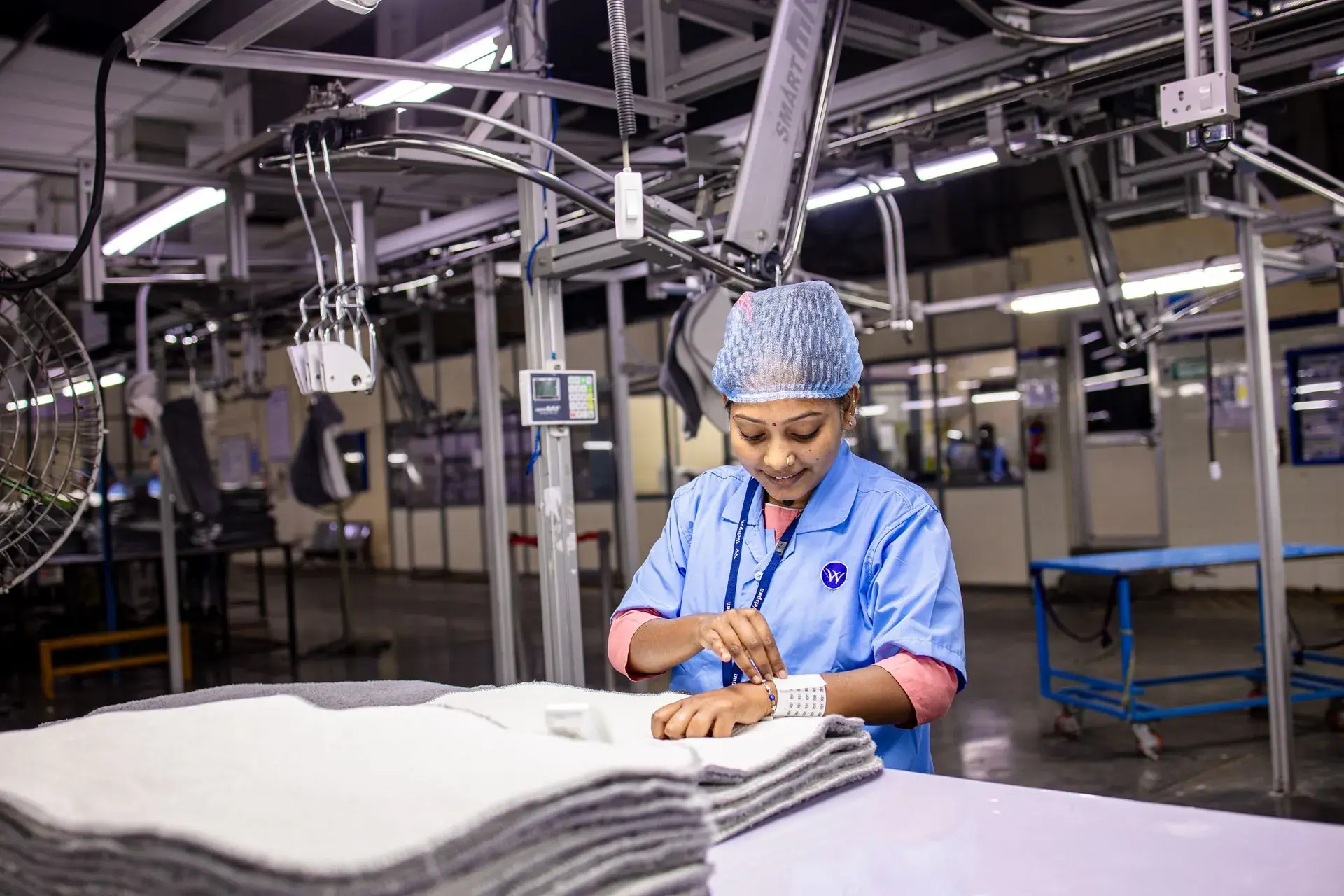 Quality checker measuring a finished garment against the spec sheet — stock illustration standing in for In-line QC checker measuring a garment on the line at Lahajam, Lahore
