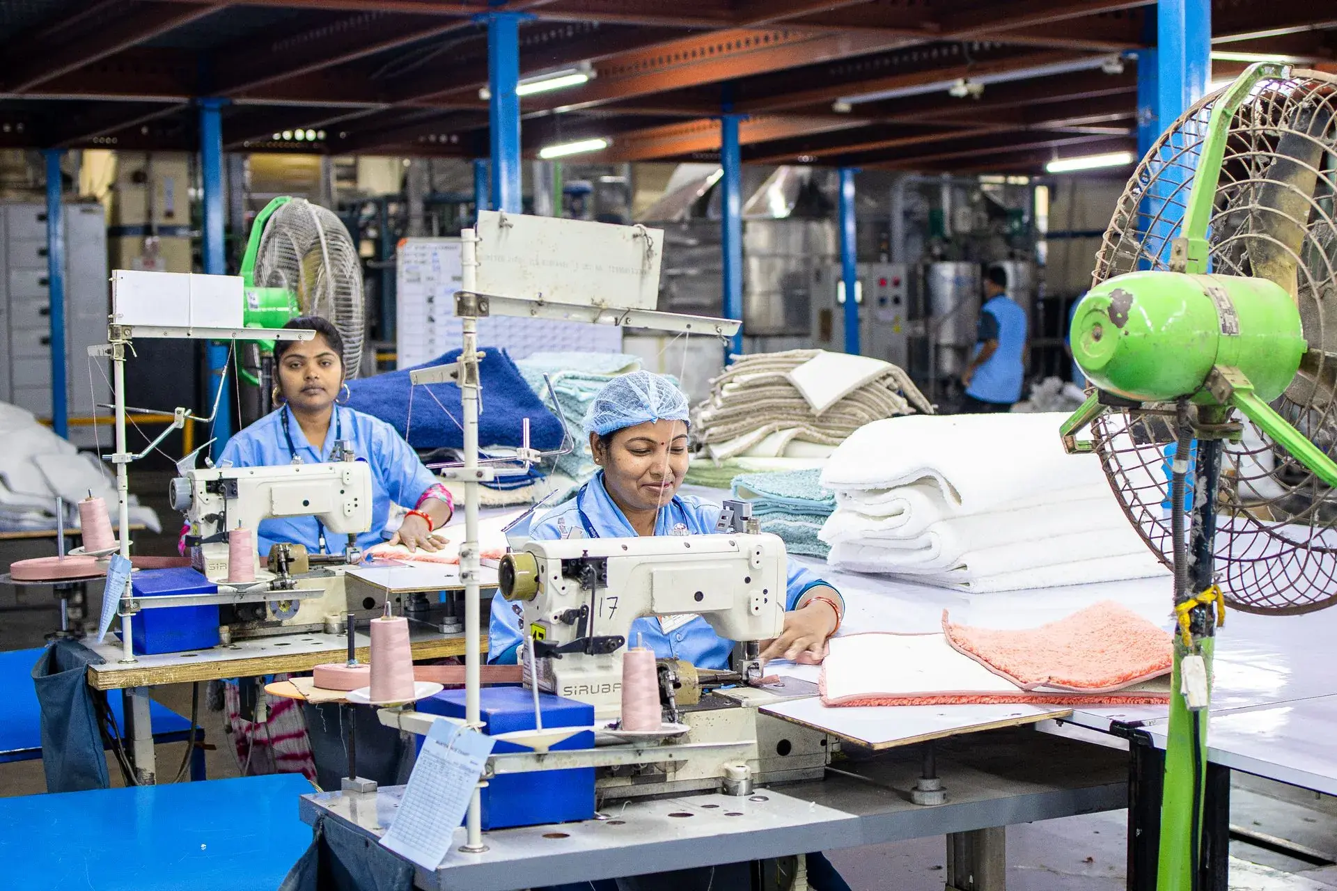 Operators stitching garments on overlock machines — stock illustration standing in for Knit line — overlock and flatlock operations in progress at Lahajam, Lahore