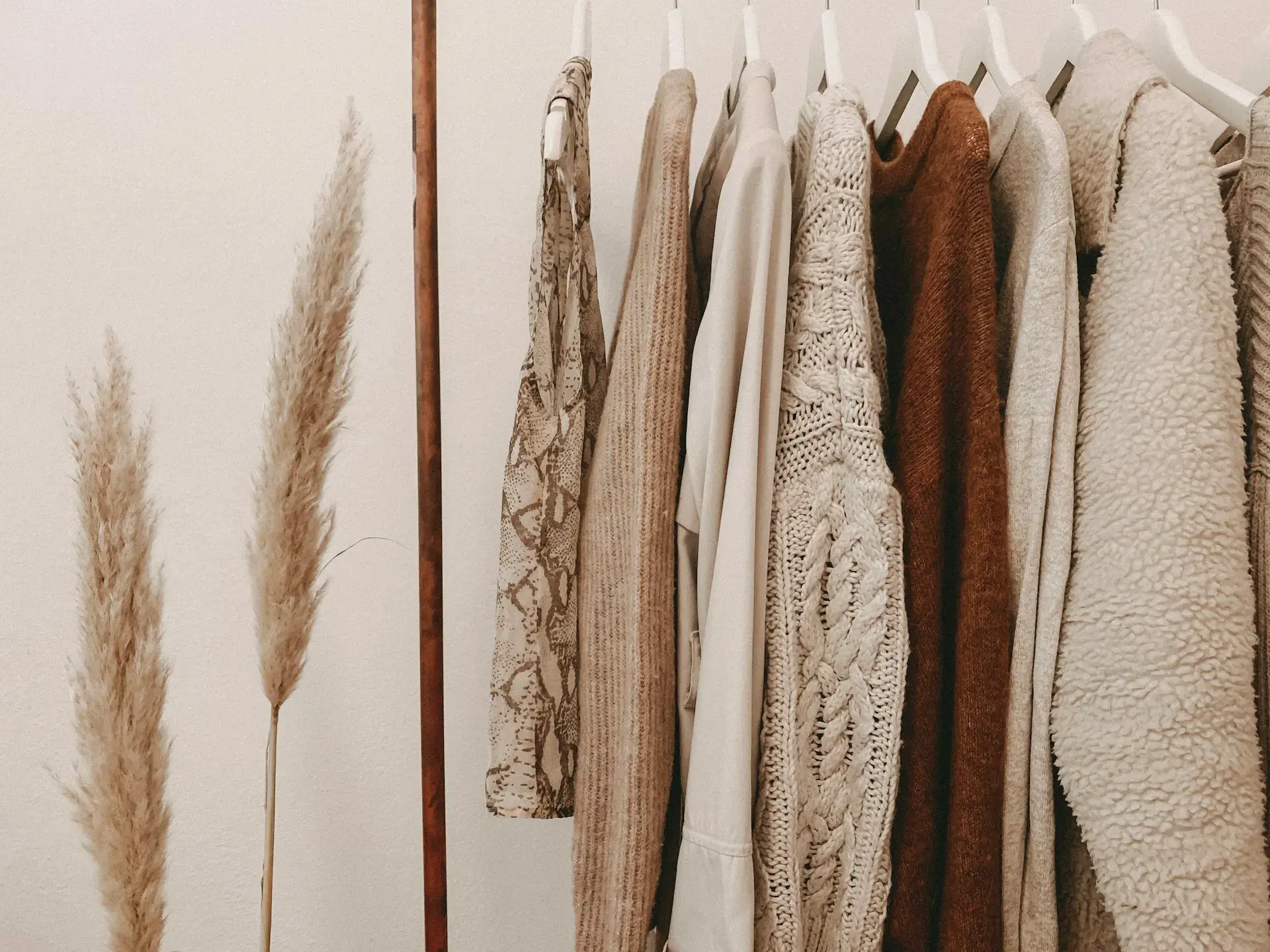 Knit sweaters hanging on a clothes rail — stock illustration for sweaters
